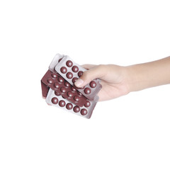 hand holding capsules and pills on white background