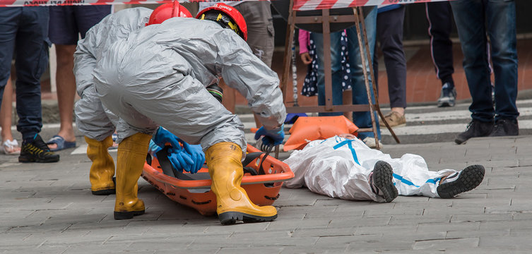 Squadra Hazmat in Tute Protettive Soccorre Vittima Contaminazione Chimica