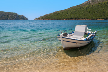 A natural port with a fishing boat anchored by the beach