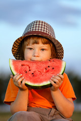 happy child eating watermelon in the garden
