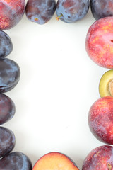 Closeup of a frame made of ripe plums isolated on white.