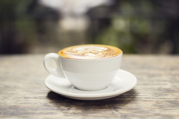 Cappuccino on a wooden table outside