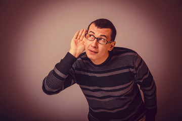 male of European appearance brunet put his hand to his ear, eave