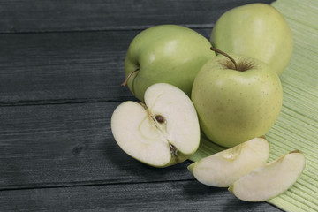 Green apples on the wooden desk and tablecloth