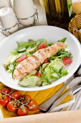 Fototapeta na wymiar Salmon grilled with mixed salad of fresh fruits and vegetables