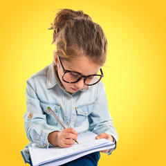 Naklejka na ściany i meble Little girl with glasses studing