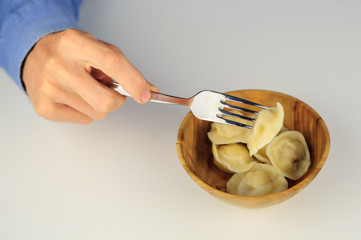 Young man eats dumplings with meat