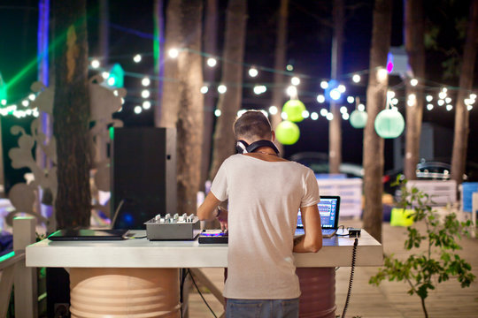 DJ at work in outdoor cafe, night photo