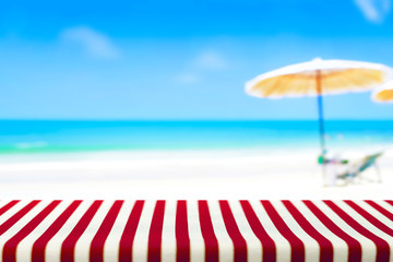 Table covered with striped tablecloth on blurred beach background