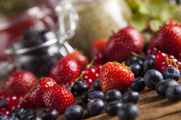 Glass of mixed berry jam with strawberries, bilberries, red currants and blackberries