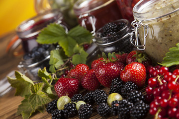 Glass of mixed berry jam with strawberries, bilberries, red currants and blackberries
