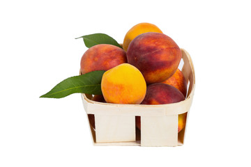 Fresh tasty peaches with green leaves in wooden box - isolated on white background