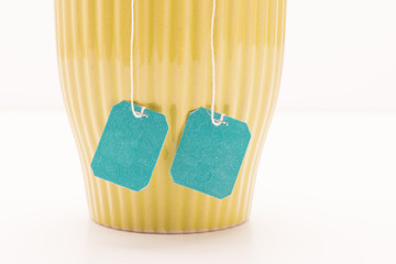 Teacup filled with strong hot tea and two teabags