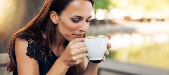 Young woman drinking cappuccino