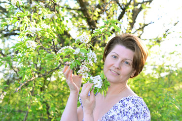 Awoman in  apple orchard at  early spring