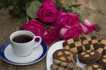 bouquet of beautiful roses, various cookies on a plate and coffe