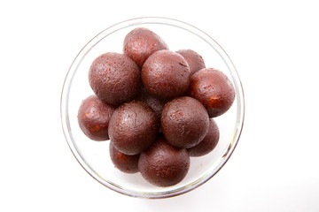 Gulab Jamun in a Glass Bowl  - An Indian sweet dish, round shaped, black or brown texture served after meals directly or with ice cream