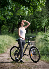 Obraz premium Girl on a bicycle in a forest