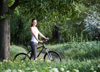 Naklejka premium Girl on a bicycle in a forest