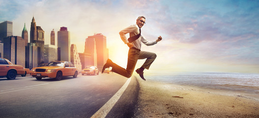 Fototapeta na wymiar Businessman jumping from a busy city to the beach