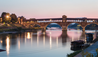 Fototapeta na wymiar Pavia, Italy: Covered bridge over the river Ticino at sunset