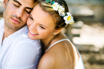 Beautiful young happy wedding couple in love hugging in the park - 90830624
