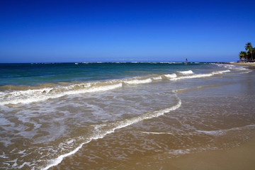 Sea waves with foam on white tropical sandy beach