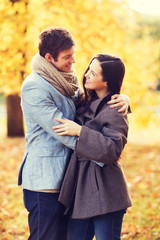 Fototapeta premium smiling couple hugging in autumn park