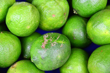Green colored fruits are on grocery shelf.