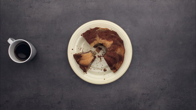 Cake and three cups of coffee on kitchen table, top view timelapse
