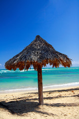 Grass leaf palm sun umbrella with caribbean sea background
