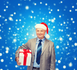 smiling man in suit and santa helper hat with gift