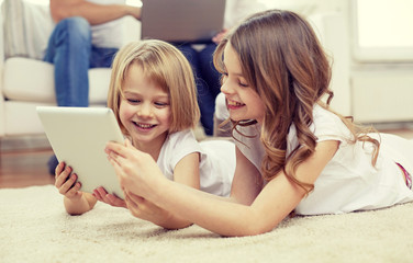 happy little girls with tablet pc computer at home