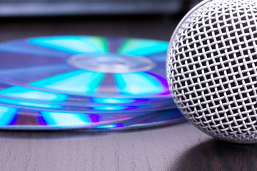 Fototapeta na wymiar Microphone and cd disks on black table