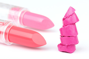 Two whole  and one sliced  lipsticks on white