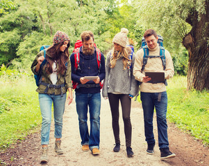 group of friends with backpacks and tablet pc