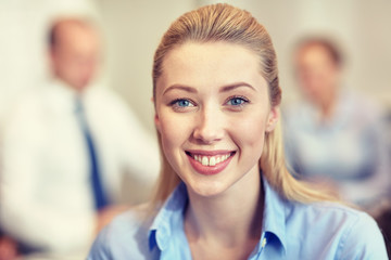 group of smiling businesspeople meeting in office