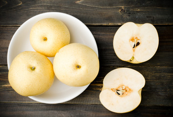 Fresh asian pear in the bowl on wooden background