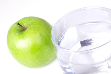 Glass with water and green apple