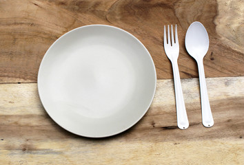 empty plate with spoon and fork ,top view. on wood background