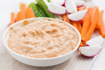 tomato sauce with tofu and fresh vegetables on wooden board
