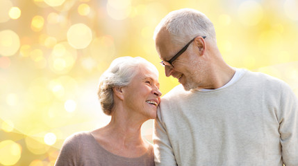 happy senior couple over holiday lights background