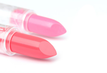 Two whole  and one sliced  lipsticks on white