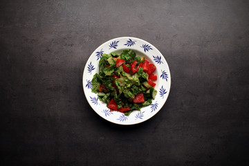 Fresh summer salad on ornamental plate, top view