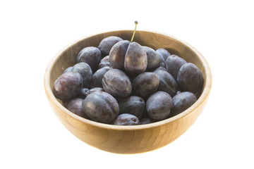 purple plums in a bamboo plate