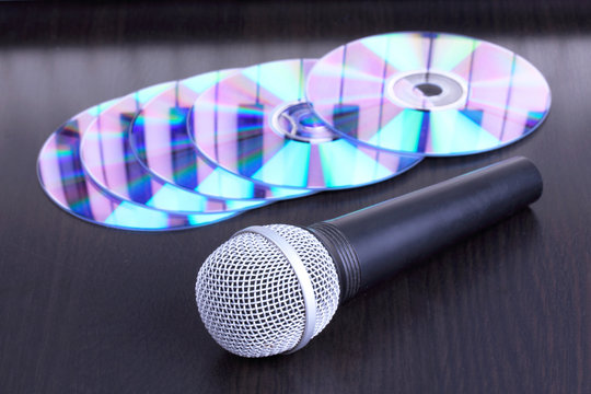 Microphone and cd disks on black table