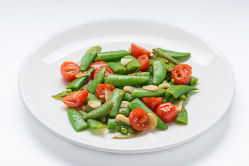 Stir fry sugar snap peas with tomato isolated on white backgroun