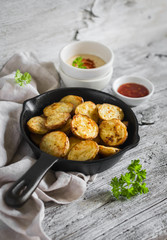 baked potatoes in the pan on a light wooden surface