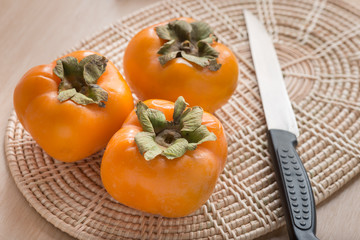 Fresh Persimmon fruit on wickerwork.