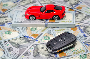 Red sport car with keys on money background